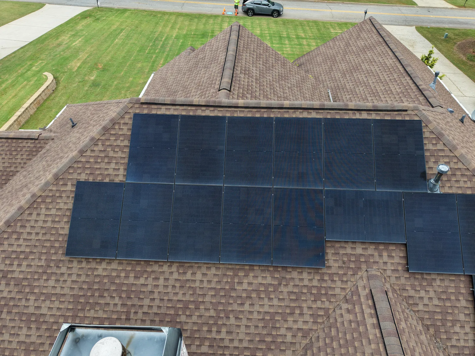 Top-down view of solar panels across a shingle roof